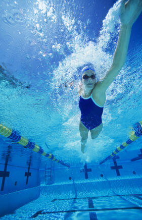 Female,Swimmer,Gushing,Through,Water,In,Pool